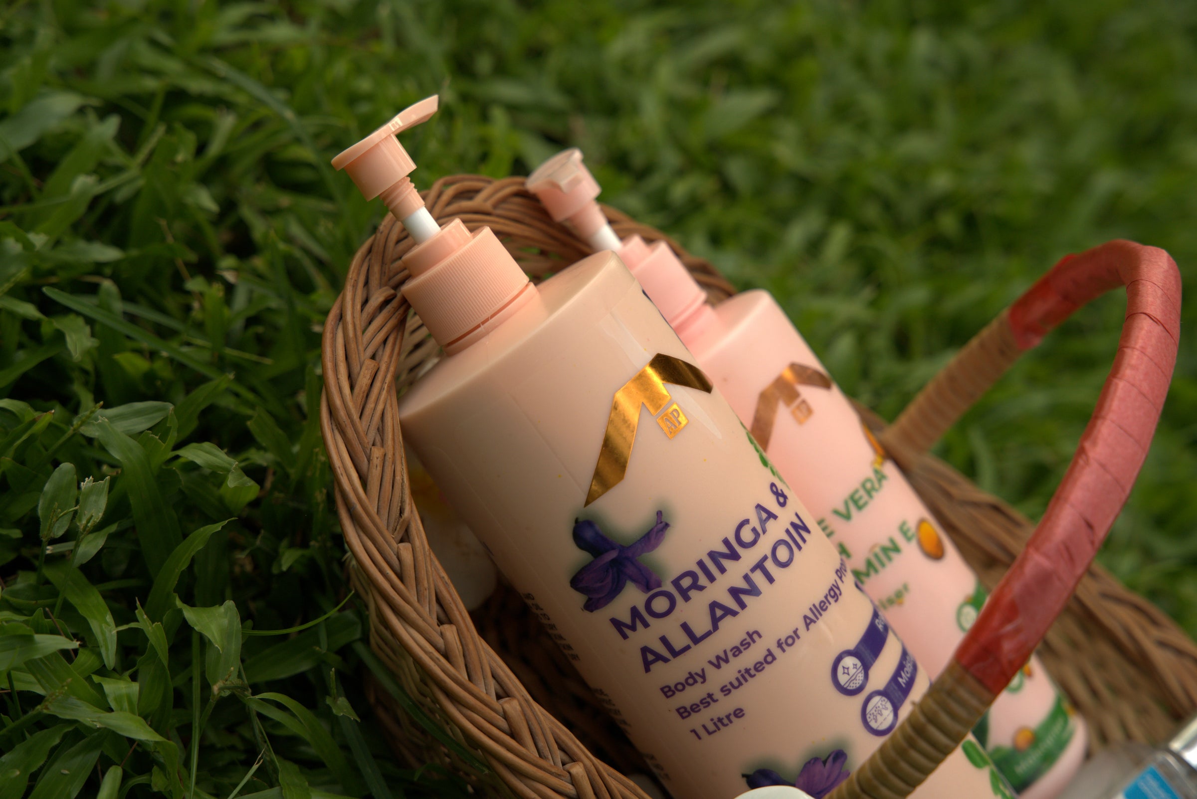 Bottle of Moringa Allantoin Cream in a wicker basket on grass