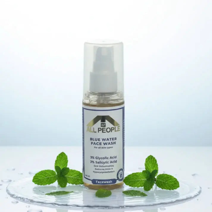 All People Blue Water Face Wash bottle with clear pump, shown front-facing on a wet surface with mint leaves around it.