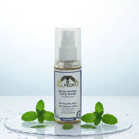 All People Blue Water Face Wash bottle with clear pump, shown front-facing on a wet surface with mint leaves around it.