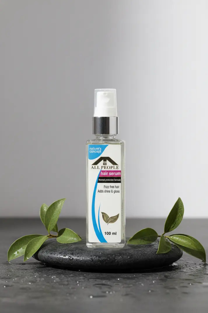 Clear spray bottle with label on a dark surface and gray background