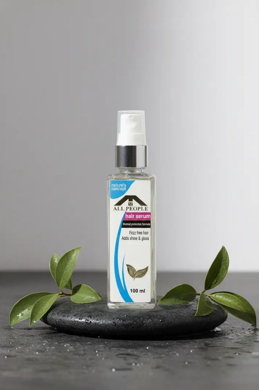 Clear spray bottle with label on a dark surface and gray background