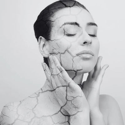 Black and white portrait of a woman with cracked skin texture.