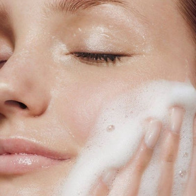 Close-up of a person applying foam to their face